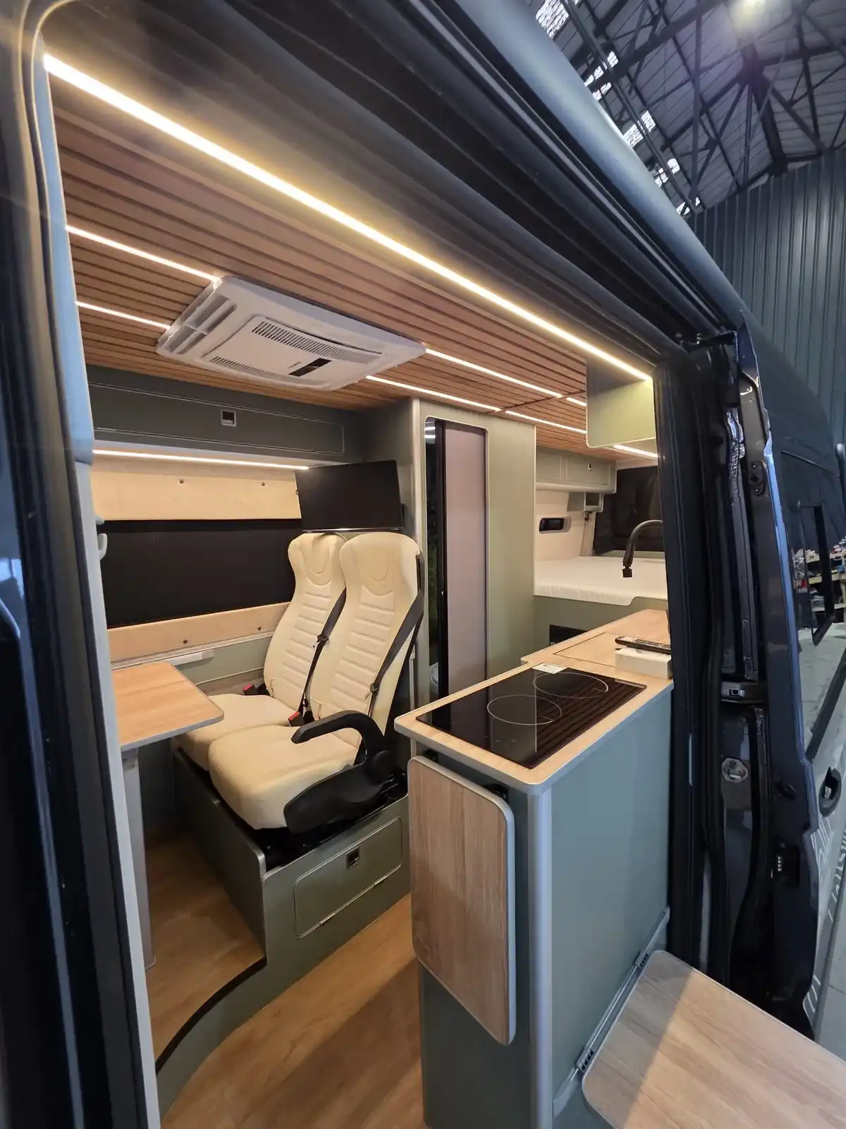 Through the sliding door to the seats and kitchen of a Luxus VW Crafter campervan